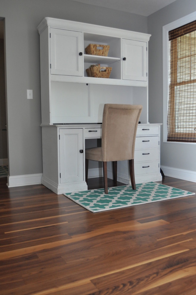 Cette photo montre un petit bureau tendance avec un mur gris, un sol en bois brun, aucune cheminée, un bureau indépendant et un sol marron.