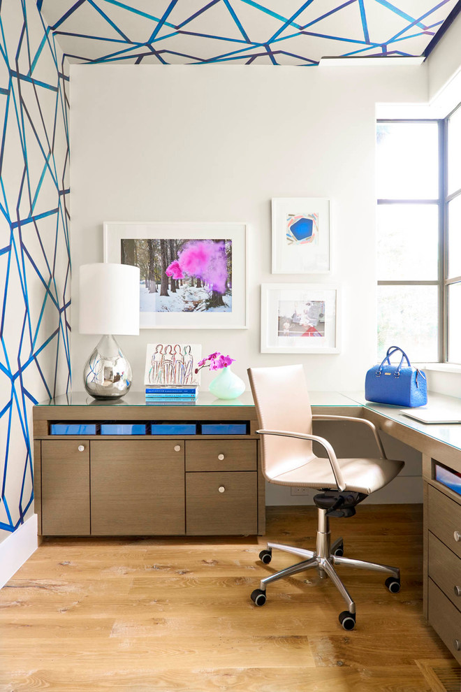На фото: кабинет в современном стиле с разноцветными стенами, светлым паркетным полом и встроенным рабочим столом с