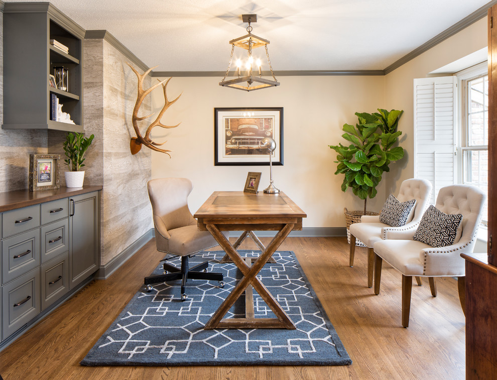 Imagen de despacho tradicional con paredes beige, suelo de madera en tonos medios, escritorio independiente y suelo marrón