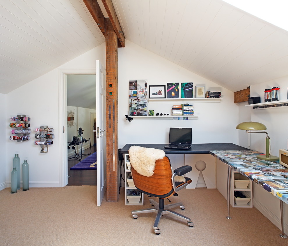 На фото: домашняя мастерская среднего размера в стиле фьюжн с белыми стенами, ковровым покрытием и встроенным рабочим столом без камина