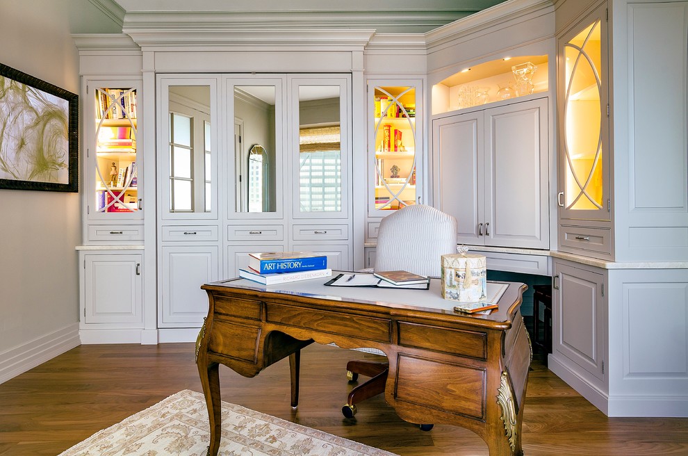 Imagen de despacho clásico de tamaño medio con suelo de madera en tonos medios, escritorio independiente y paredes beige