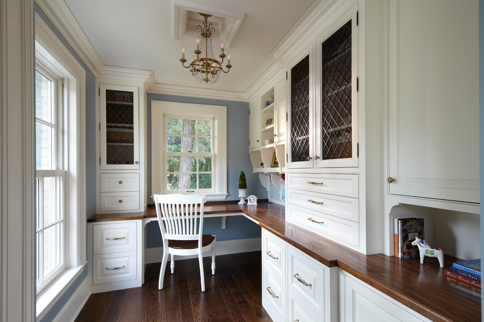 На фото: кабинет в классическом стиле с синими стенами и встроенным рабочим столом с