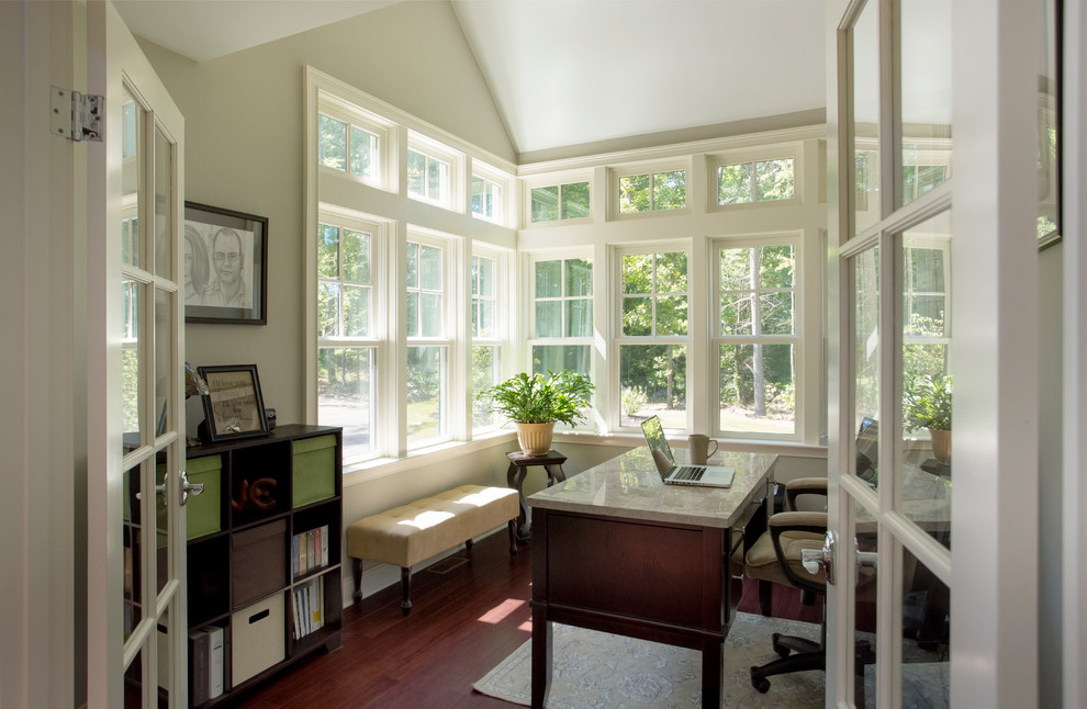 Kleines Klassisches Arbeitszimmer ohne Kamin mit Arbeitsplatz, beiger Wandfarbe, dunklem Holzboden und freistehendem Schreibtisch in Boston