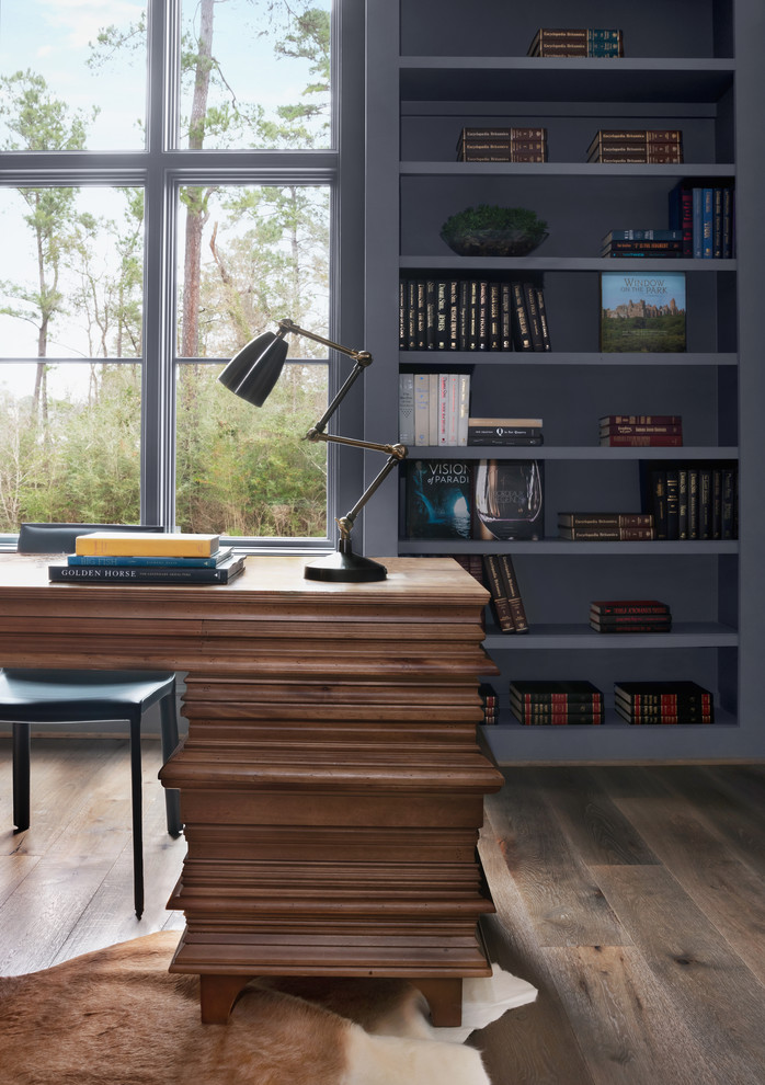 Modelo de despacho tradicional renovado grande con paredes grises, suelo de madera oscura, escritorio independiente y suelo marrón