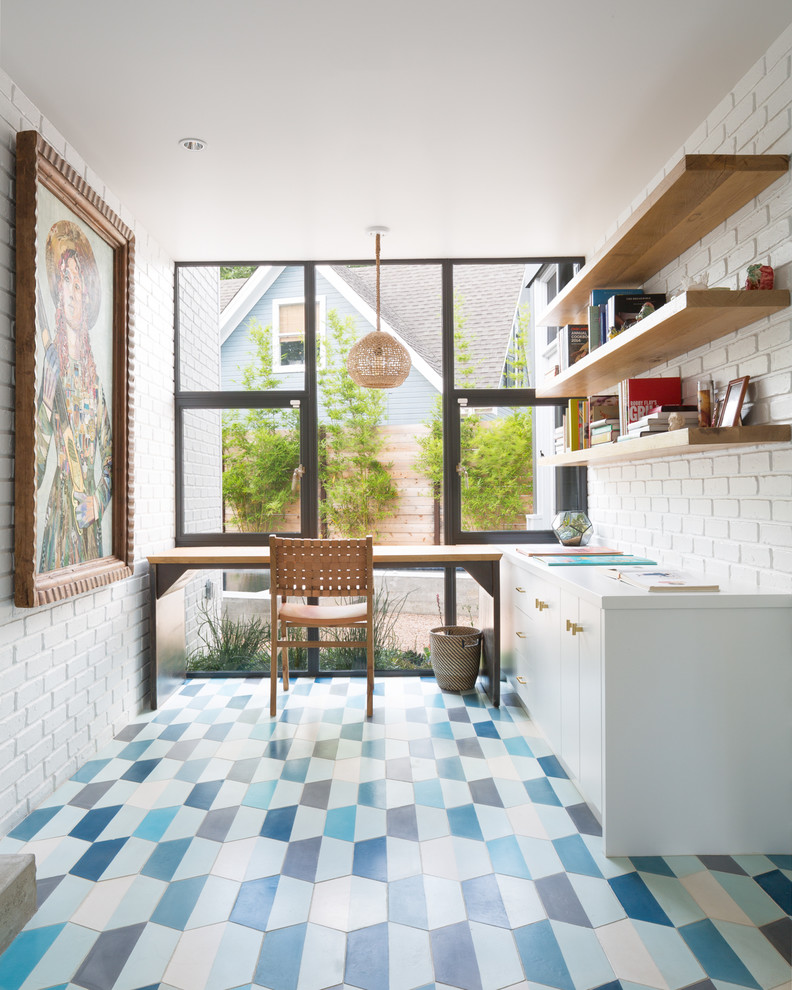 オースティンにある高級な中くらいなモダンスタイルのおしゃれなホームオフィス・書斎 (白い壁、自立型机、青い床) の写真