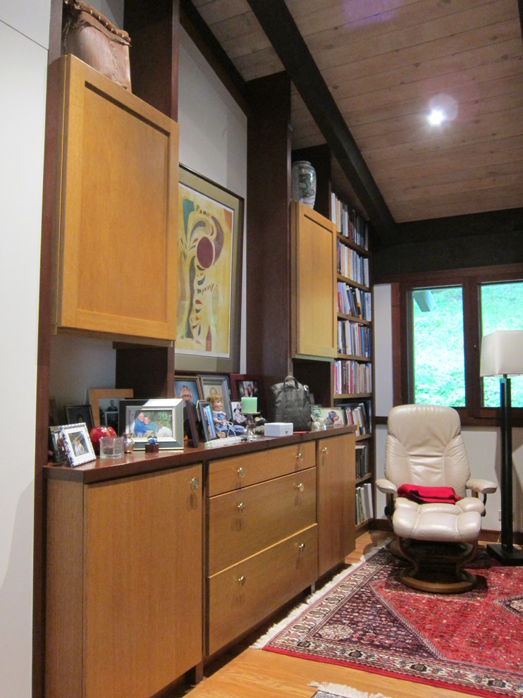 Exempel på ett asiatiskt hemmabibliotek, med vita väggar och ljust trägolv