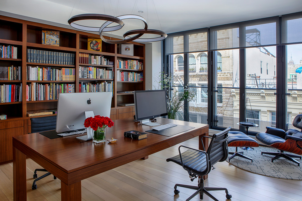 ニューヨークにあるラグジュアリーな広いトランジショナルスタイルのおしゃれなホームオフィス・書斎 (白い壁、淡色無垢フローリング、暖炉なし、自立型机、ベージュの床、ライブラリー) の写真