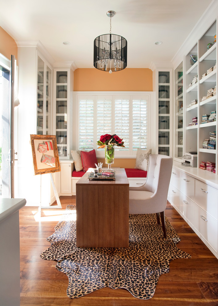 Inspiration pour un bureau design de taille moyenne avec un mur orange, parquet foncé, aucune cheminée, un bureau indépendant et un sol marron.