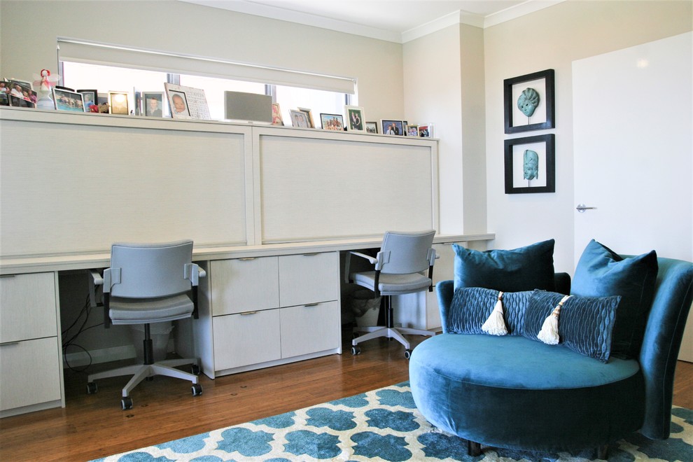 Ejemplo de despacho minimalista grande con paredes blancas, suelo de madera oscura, escritorio empotrado y suelo marrón