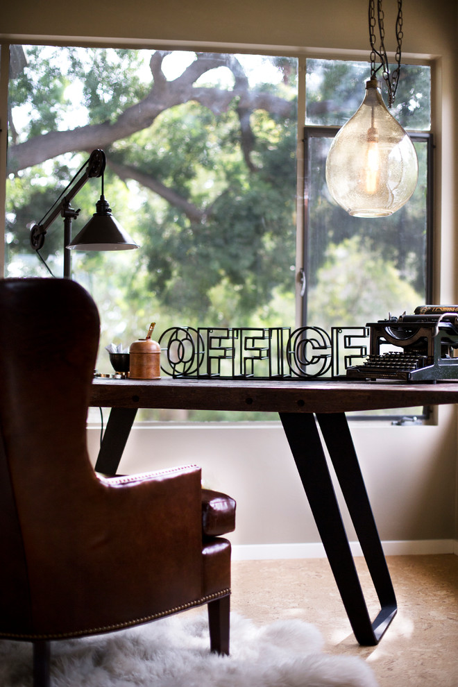 Imagen de despacho industrial pequeño con paredes beige, suelo de corcho y escritorio independiente