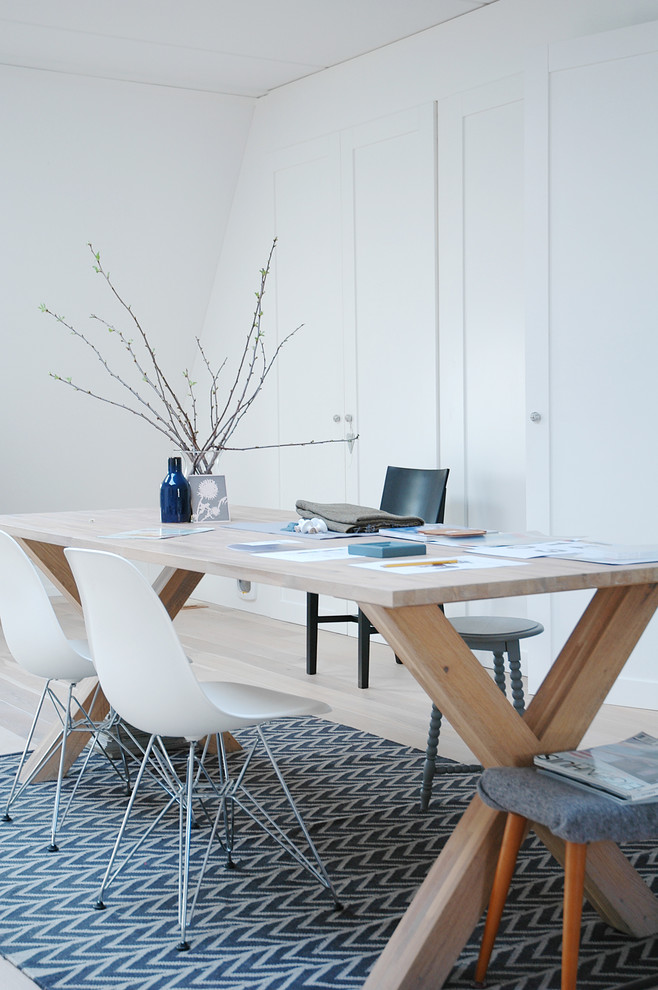 Idéer för ett skandinaviskt arbetsrum, med vita väggar, mellanmörkt trägolv och ett fristående skrivbord