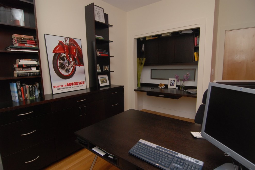 Modelo de despacho contemporáneo de tamaño medio con paredes beige, suelo de madera en tonos medios y escritorio independiente