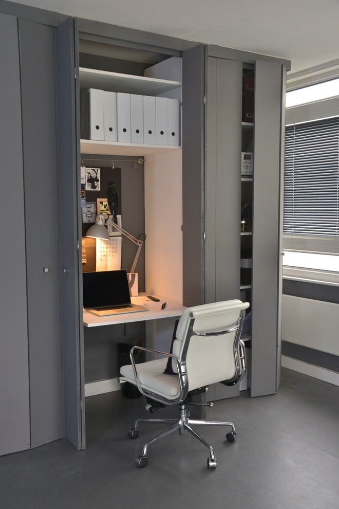 Home office - small contemporary built-in desk gray floor home office idea in London with gray walls