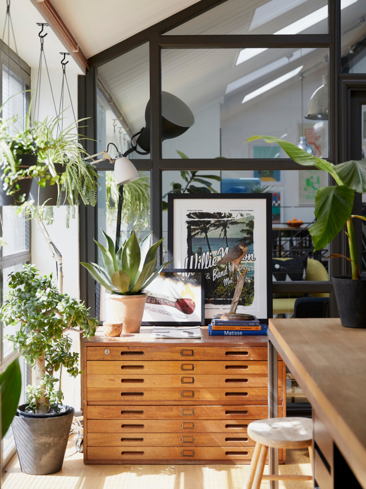 Großes Industrial Arbeitszimmer mit Studio, braunem Holzboden, freistehendem Schreibtisch und braunem Boden in London