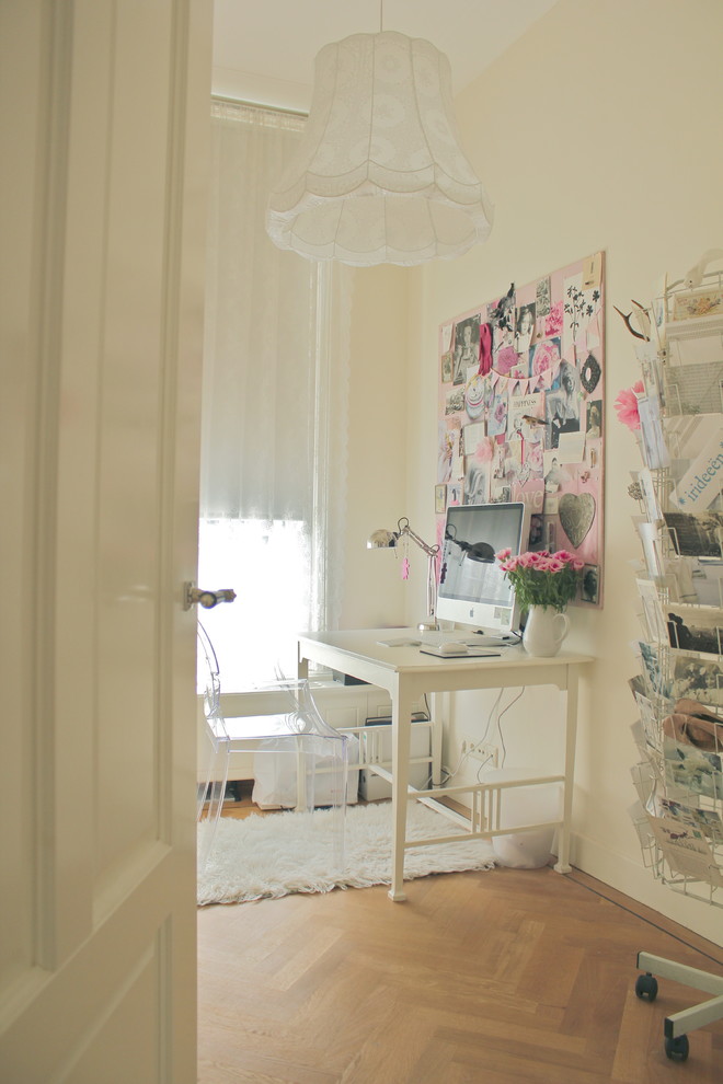 Home office - eclectic freestanding desk medium tone wood floor home office idea in Amsterdam with white walls
