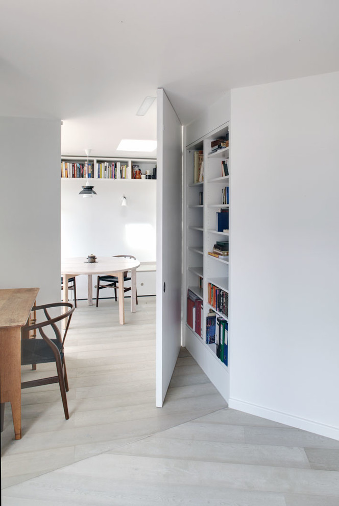 Photo of a medium sized contemporary study in London with white walls, light hardwood flooring, no fireplace and a freestanding desk.