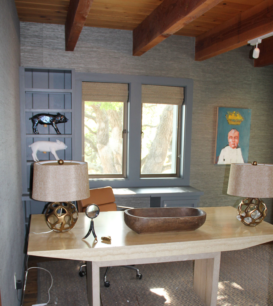 Modelo de despacho actual de tamaño medio sin chimenea con paredes azules, suelo de madera en tonos medios y escritorio independiente