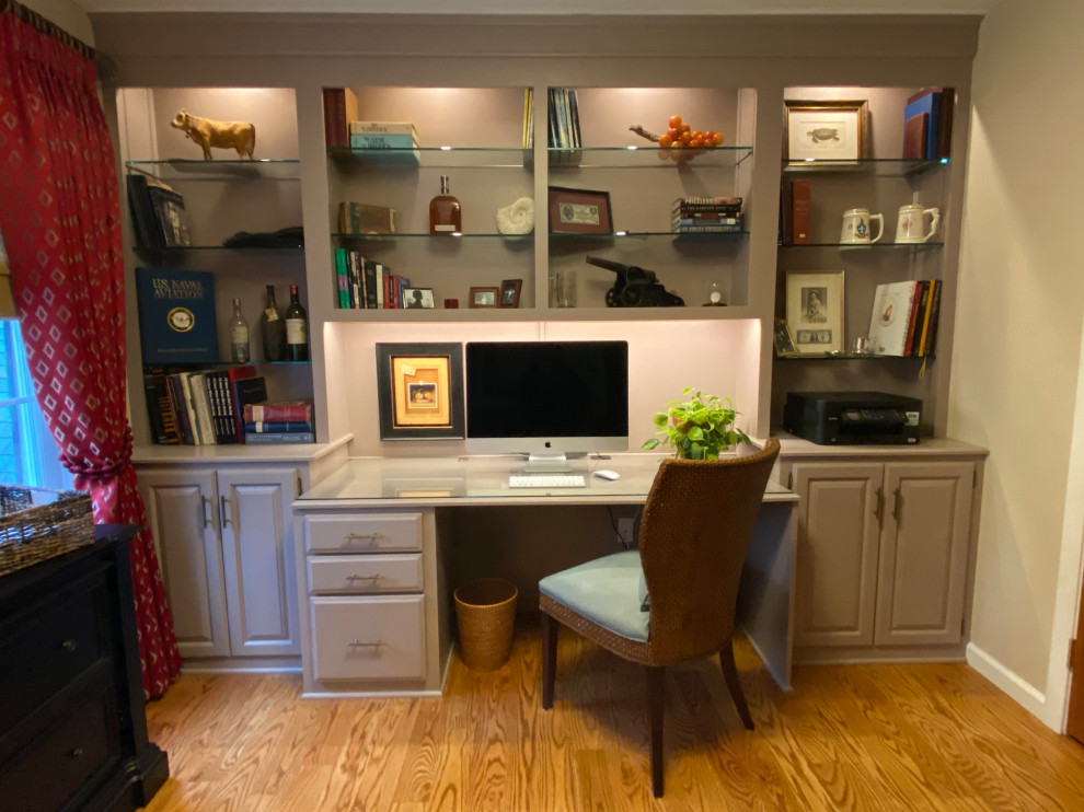 Imagen de despacho tradicional pequeño con paredes beige, suelo de madera en tonos medios, escritorio empotrado y suelo marrón