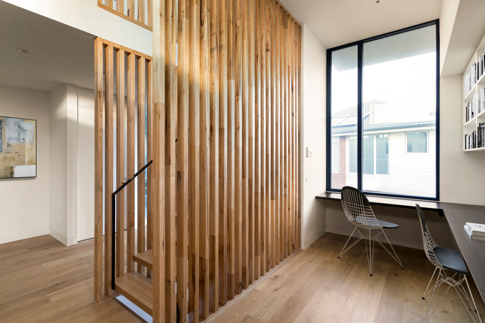 Idee per un ufficio contemporaneo di medie dimensioni con pareti bianche, parquet chiaro, scrivania incassata e pavimento marrone