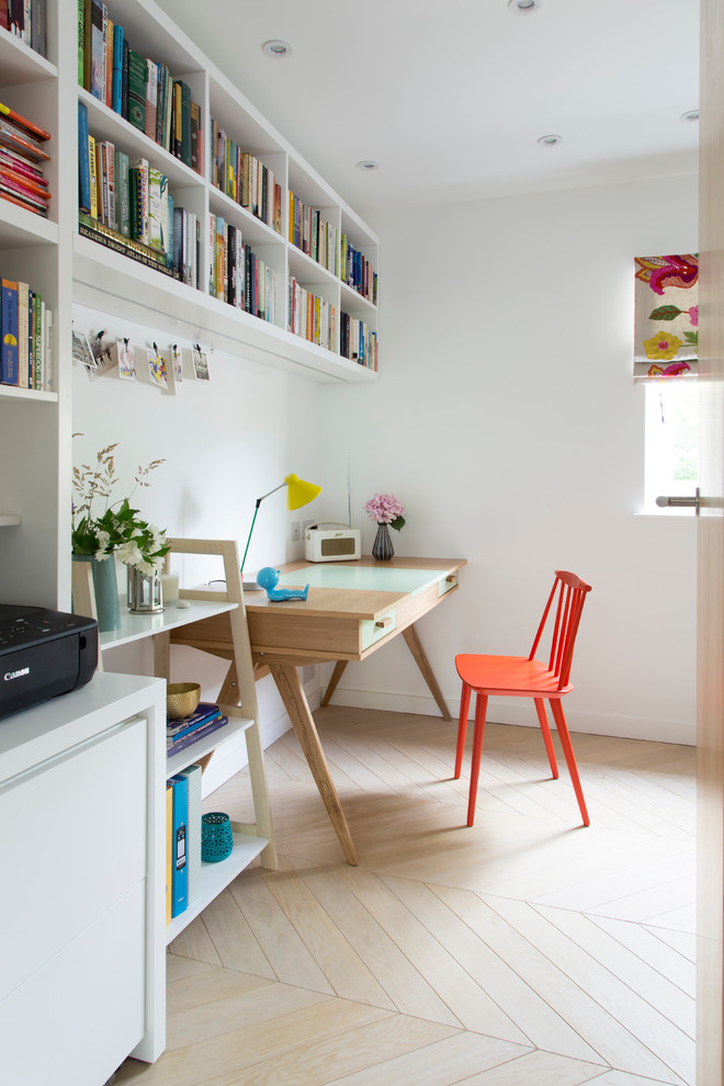 Idéer för ett mellanstort eklektiskt hemmabibliotek, med vita väggar, ljust trägolv, ett fristående skrivbord och beiget golv