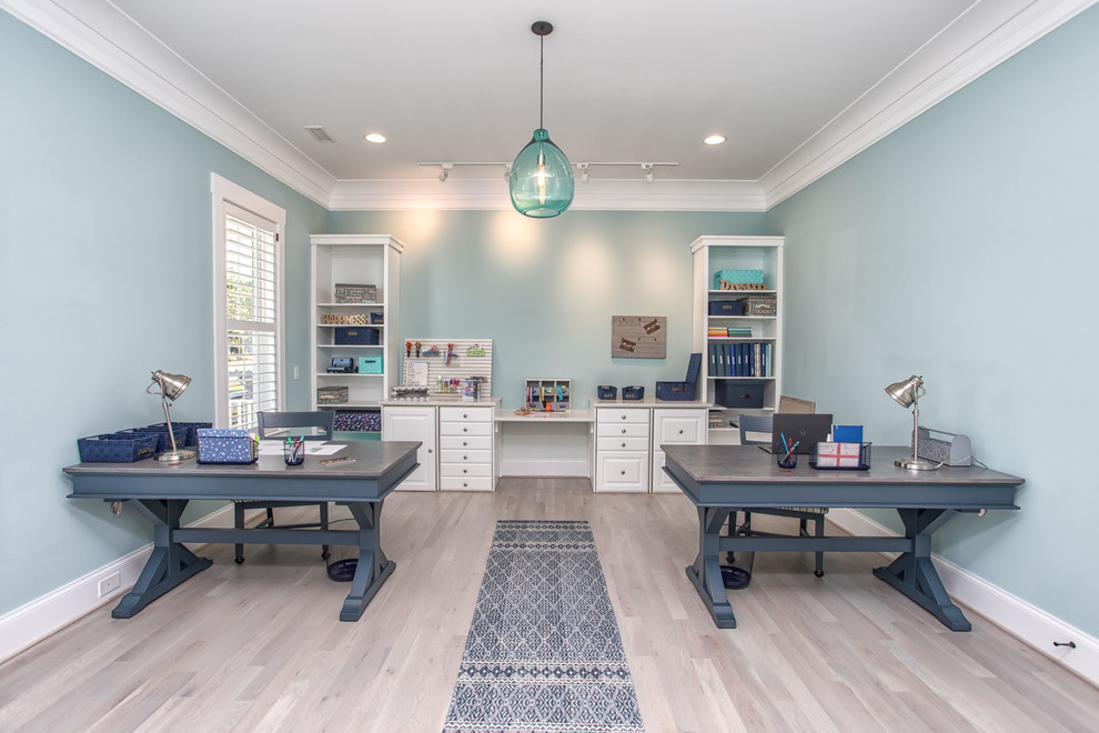 Idee per un ufficio stile marino con pareti blu, parquet chiaro, scrivania autoportante e pavimento beige