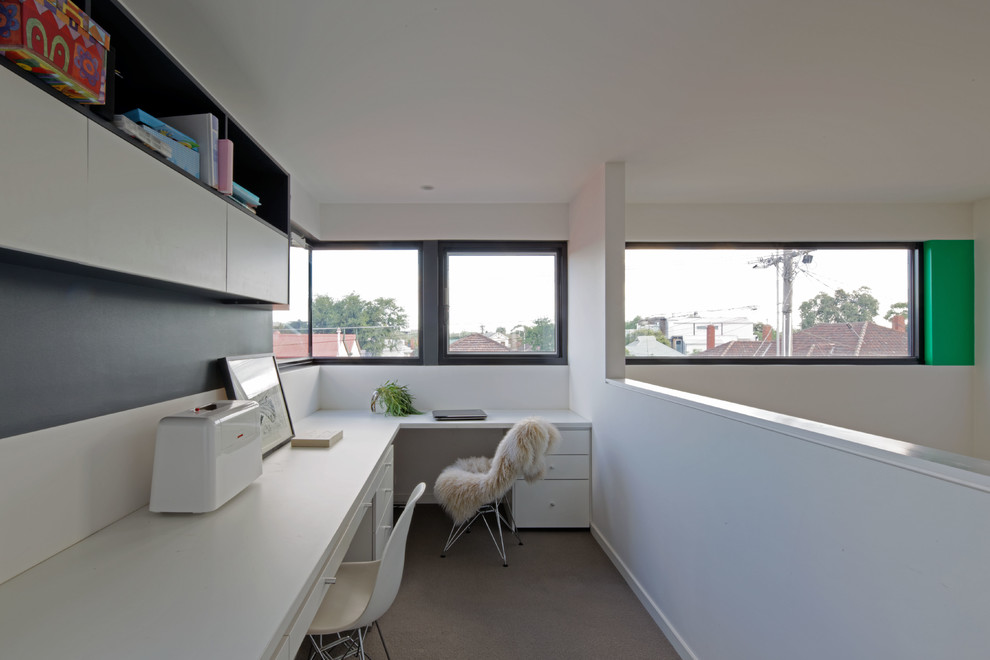 Cette image montre un petit bureau design avec un mur blanc, moquette et un bureau intégré.