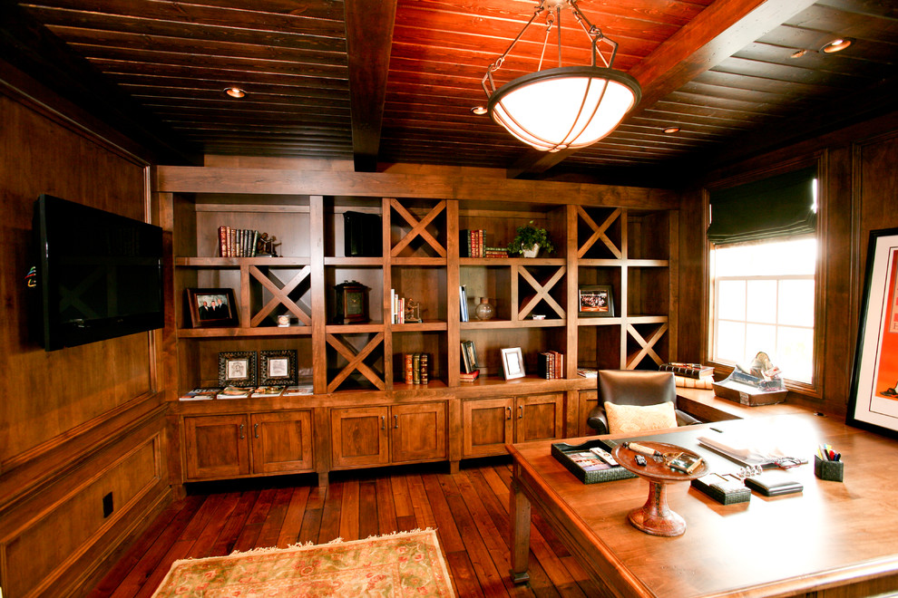 Imagen de despacho de estilo americano de tamaño medio sin chimenea con escritorio empotrado, paredes marrones, suelo de madera en tonos medios y suelo marrón