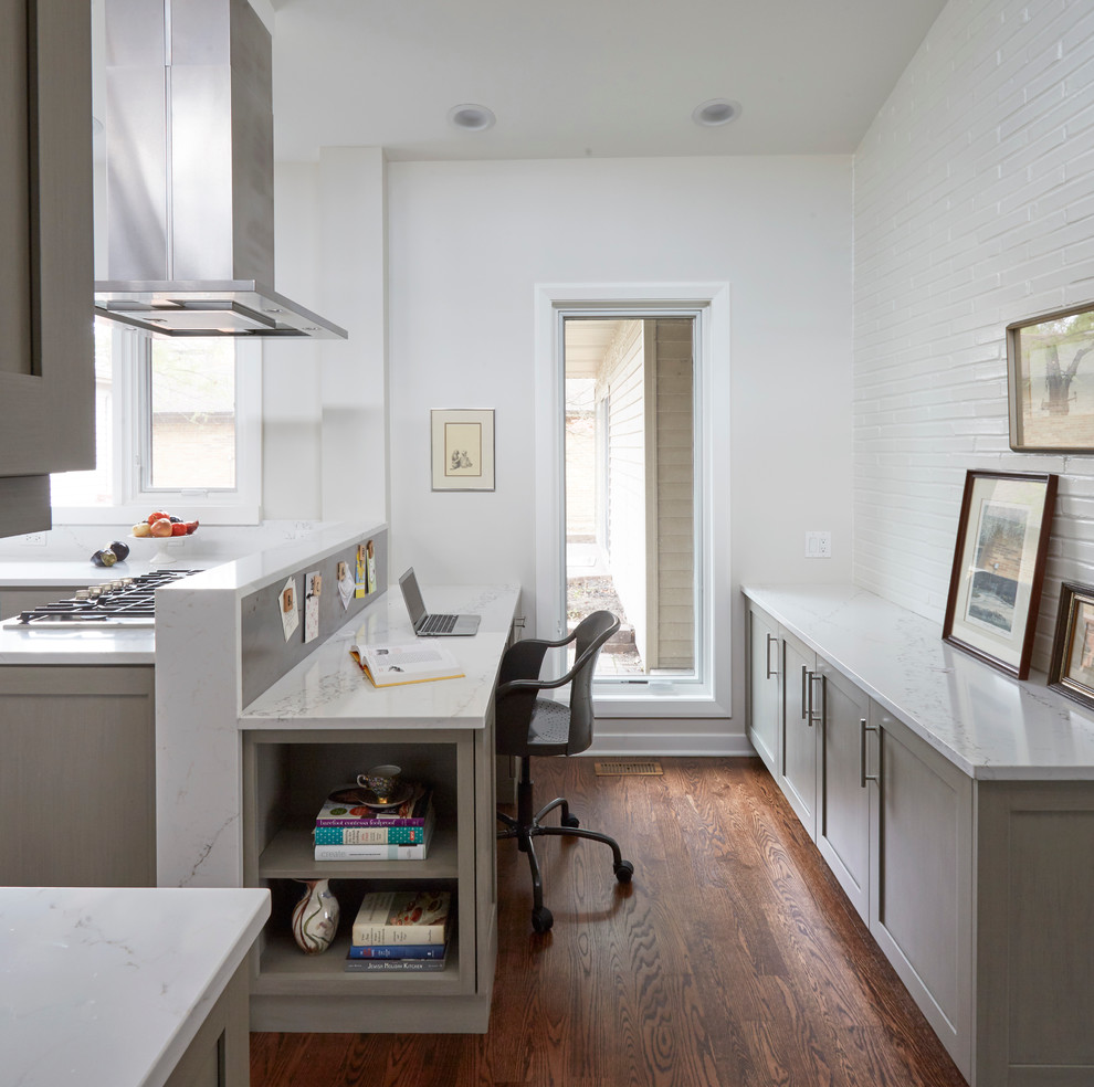 Inspiration pour un petit bureau traditionnel avec un mur blanc, parquet foncé, aucune cheminée, un bureau intégré et un sol marron.