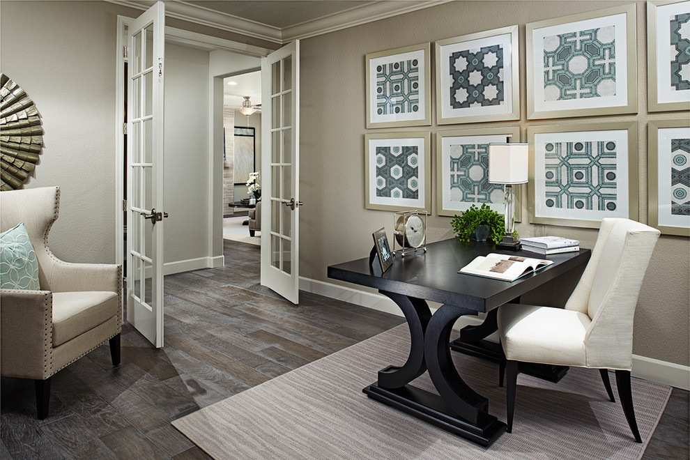 Diseño de despacho contemporáneo con paredes beige, suelo de madera oscura, escritorio independiente y suelo marrón