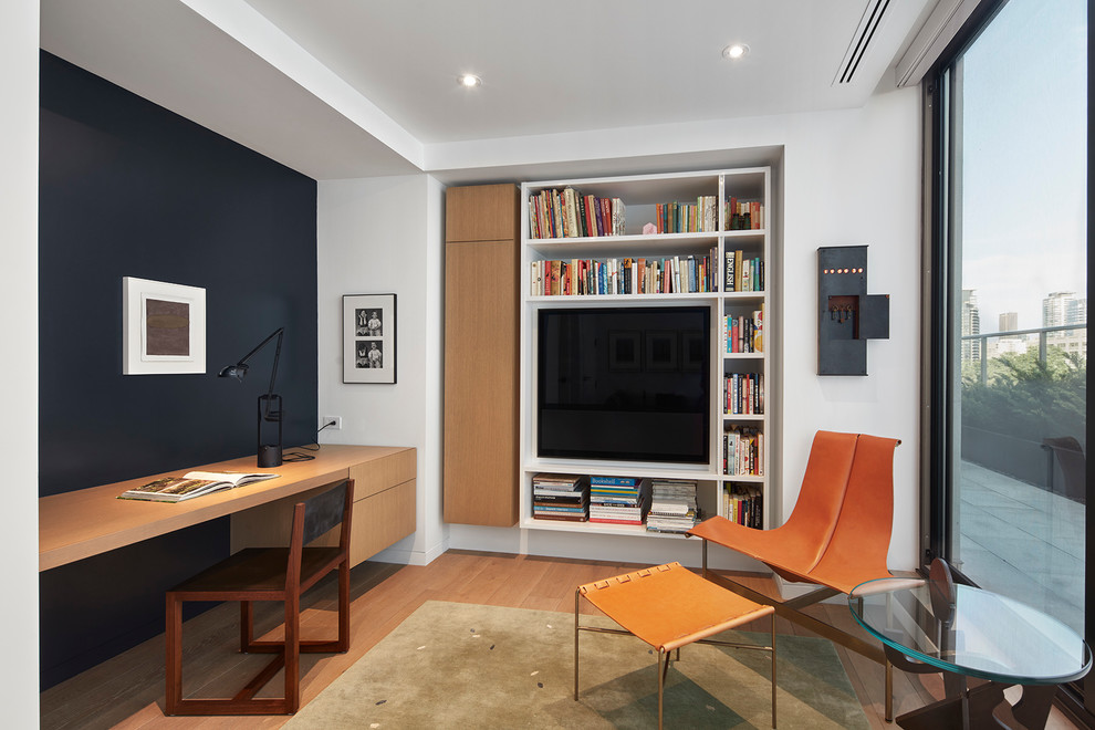 Diseño de despacho ecléctico sin chimenea con biblioteca, paredes negras, escritorio empotrado y suelo de madera clara