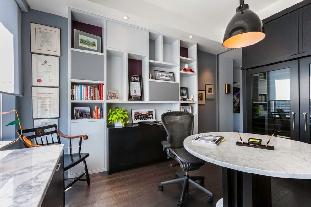 На фото: кабинет в современном стиле с серыми стенами, темным паркетным полом и встроенным рабочим столом с