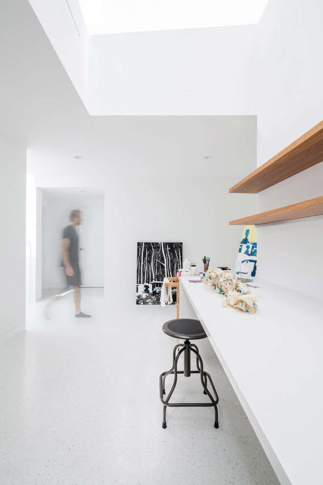 This is an example of a large modern home studio in Los Angeles with white walls and a built-in desk.