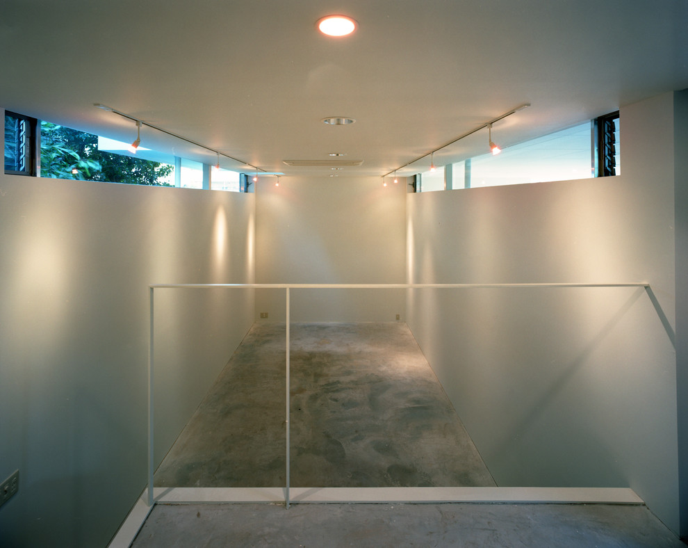 Mittelgroßes Modernes Arbeitszimmer ohne Kamin mit Studio, weißer Wandfarbe, Betonboden, Einbau-Schreibtisch, grauem Boden und Kaminumrandung aus Beton in Tokio
