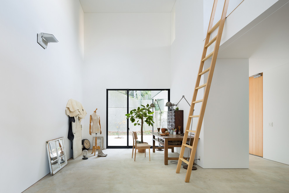 横浜にあるコンテンポラリースタイルのおしゃれなホームオフィス・書斎 (白い壁、コンクリートの床、自立型机) の写真