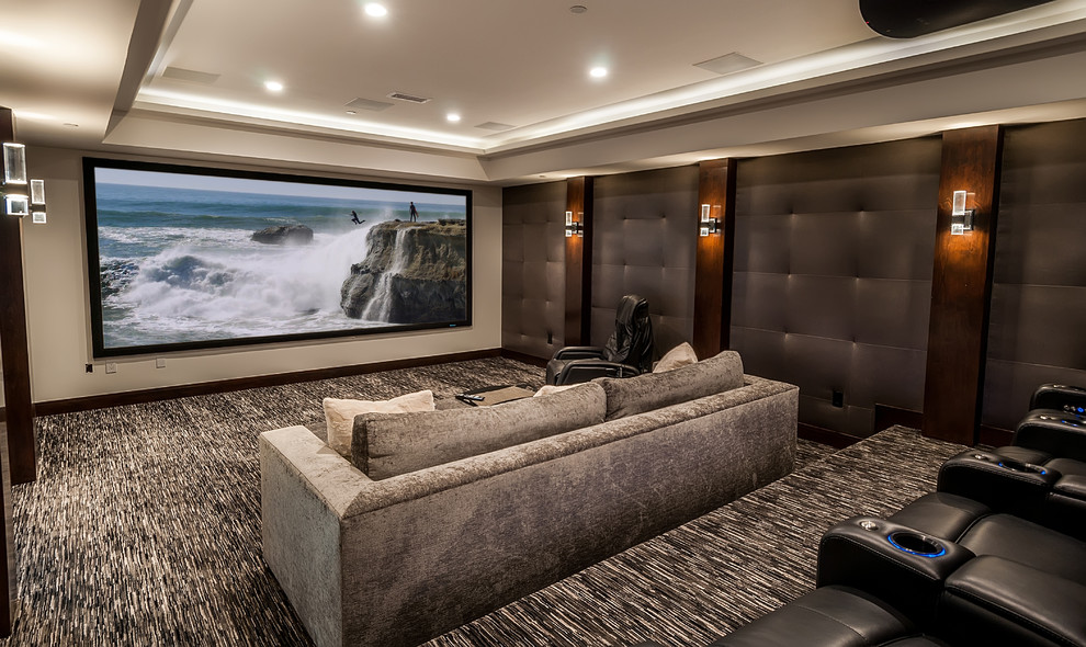 Cette image montre une salle de cinéma design fermée avec un mur gris, moquette, un écran de projection et un sol gris.