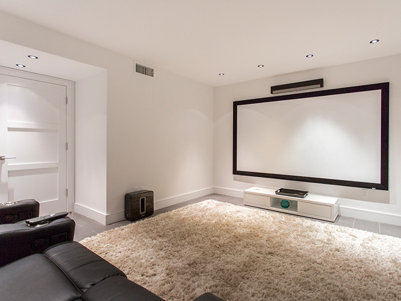 Esempio di un home theatre minimalista chiuso con pareti bianche, schermo di proiezione e pavimento grigio