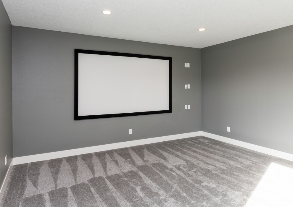 Réalisation d'une grande salle de cinéma minimaliste ouverte avec un mur gris, moquette, un écran de projection et un sol gris.