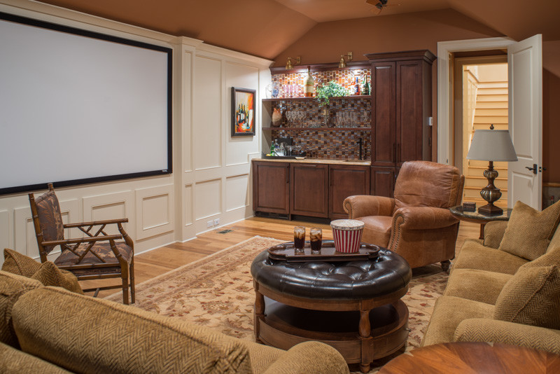 Ejemplo de cine en casa cerrado clásico de tamaño medio con paredes marrones, suelo de madera clara y pantalla de proyección