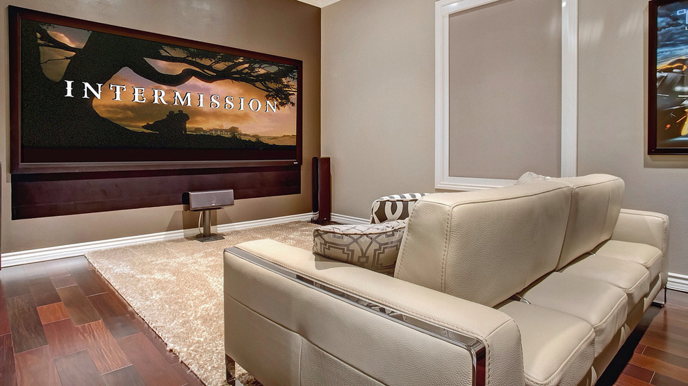 Diseño de cine en casa clásico renovado grande con paredes beige y suelo de madera en tonos medios
