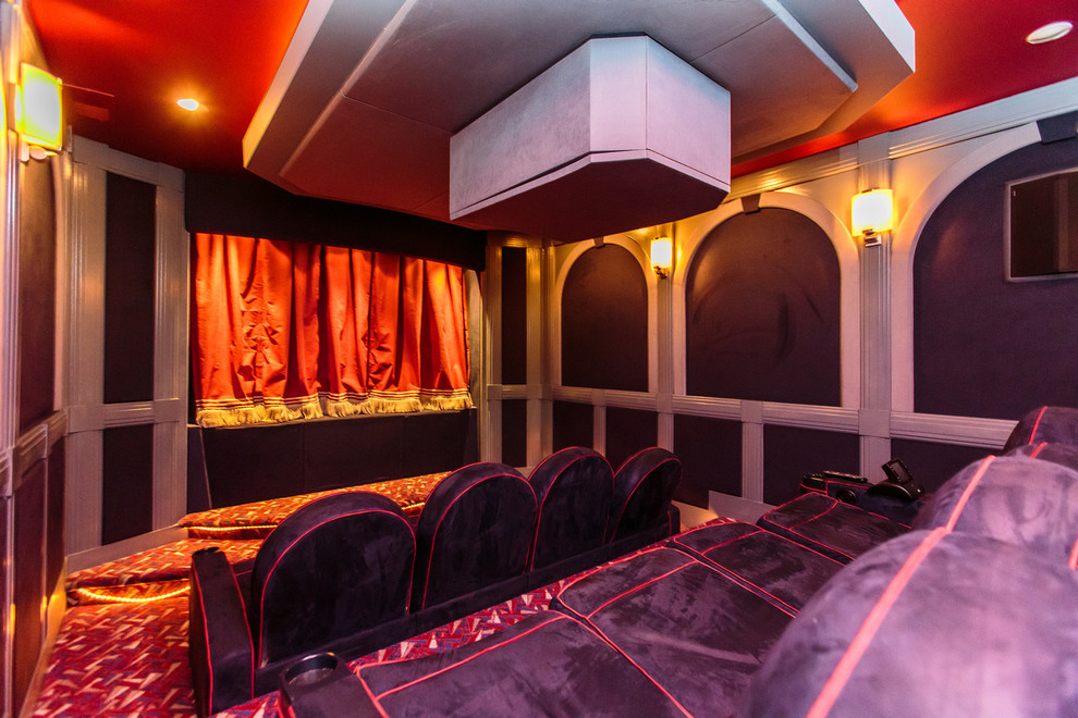 This is an example of an expansive traditional enclosed home cinema in Boston with purple walls, carpet and a projector screen.