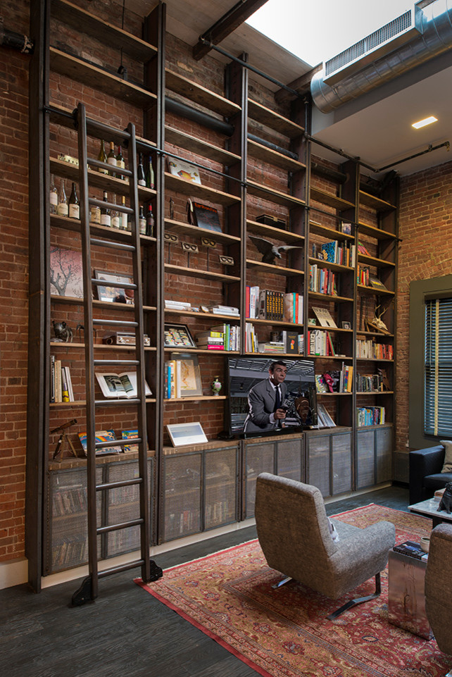 Photo of an expansive industrial enclosed home cinema in New York with brown walls, dark hardwood flooring and a built-in media unit.