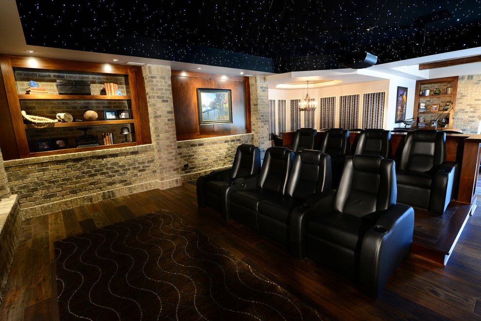 ラグジュアリーな広いトラディショナルスタイルのおしゃれなオープンシアタールーム (濃色無垢フローリング、マルチカラーの壁、プロジェクタースクリーン、茶色い床) の写真