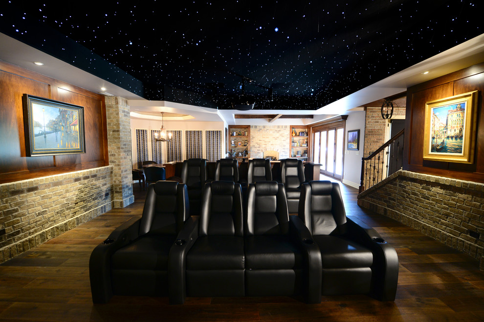 Diseño de cine en casa abierto clásico grande con suelo de madera oscura, paredes multicolor, pantalla de proyección y suelo marrón