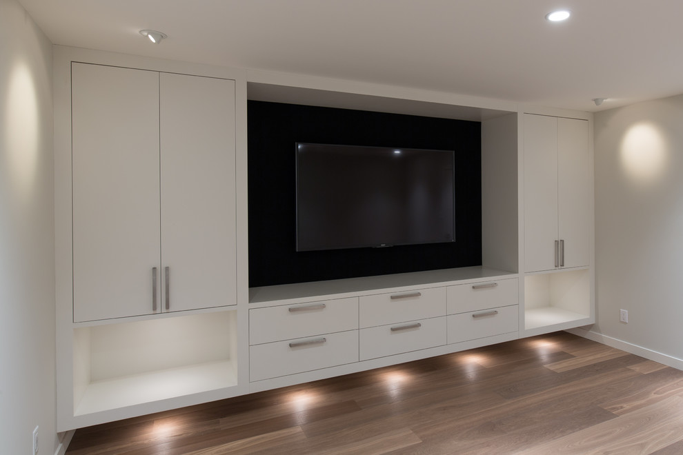 Immagine di un home theatre minimalista chiuso con pavimento in legno massello medio e TV a parete