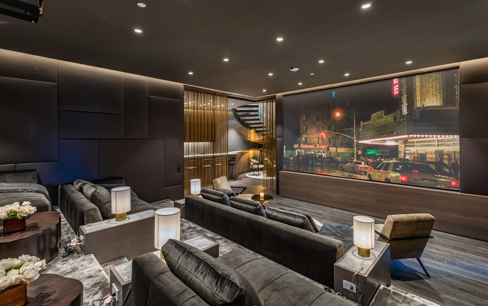 Exemple d'une grande salle de cinéma tendance ouverte avec un mur gris, un écran de projection et un sol marron.