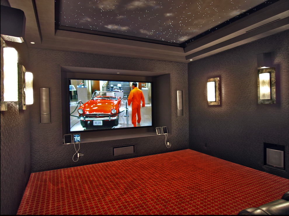 Идея дизайна: большой изолированный домашний кинотеатр в современном стиле с черными стенами, ковровым покрытием, телевизором на стене и красным полом