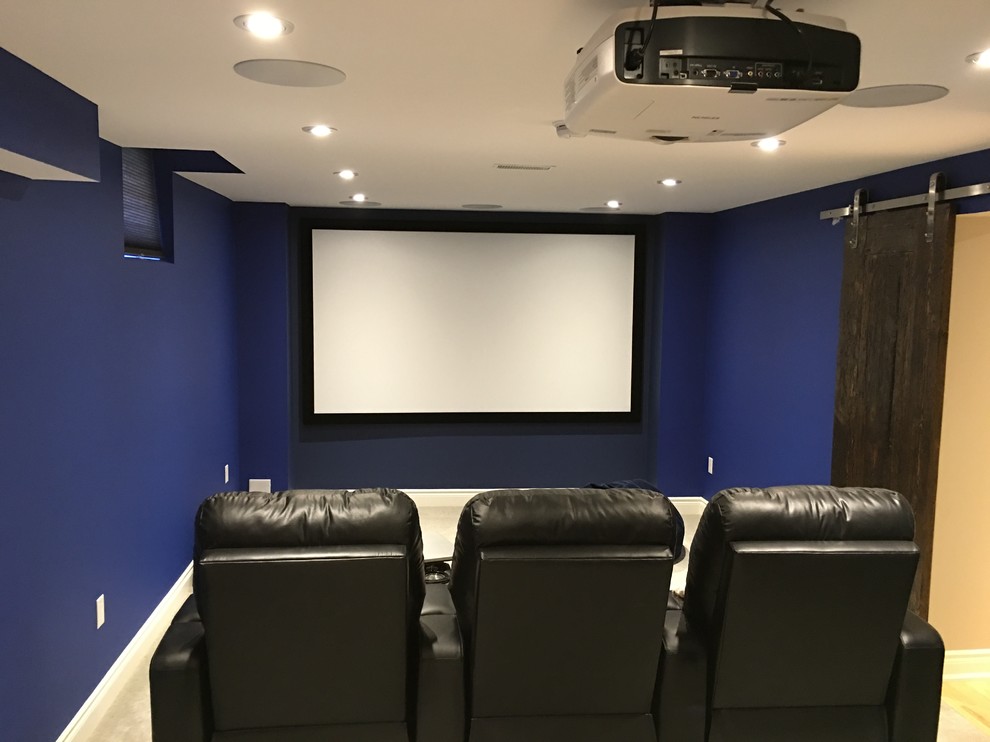 Diseño de cine en casa cerrado tradicional con paredes azules, moqueta y pantalla de proyección
