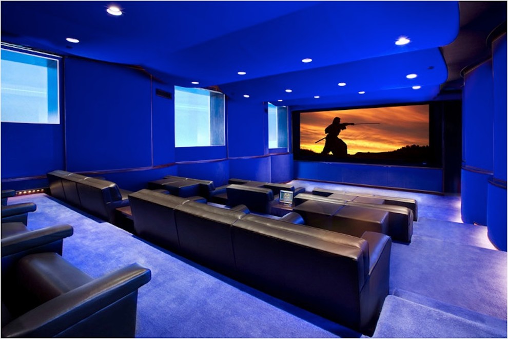 Immagine di un home theatre industriale di medie dimensioni e chiuso con pareti blu, moquette, schermo di proiezione e pavimento blu