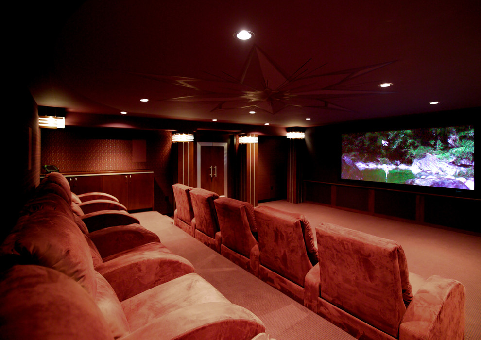 Imagen de cine en casa cerrado tradicional grande con paredes rojas, moqueta y pared multimedia
