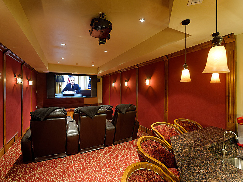 Medium sized rustic enclosed home cinema in Denver with carpet, a projector screen and red walls.